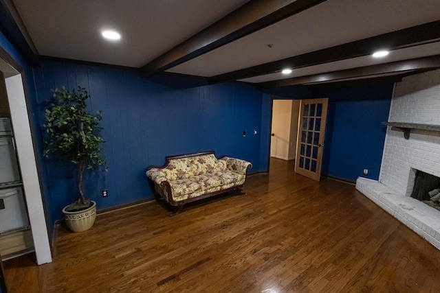 unfurnished room with beamed ceiling, a fireplace, and dark wood-type flooring