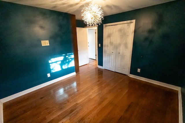 spare room featuring hardwood / wood-style flooring and a notable chandelier