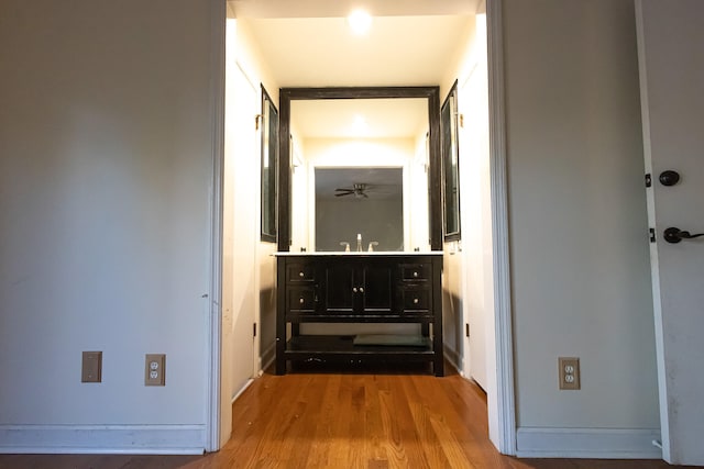 corridor featuring sink and hardwood / wood-style flooring