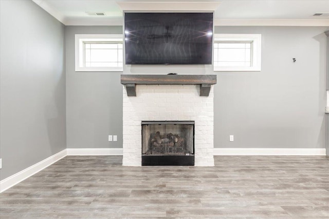 unfurnished living room featuring crown molding, hardwood / wood-style flooring, and a brick fireplace