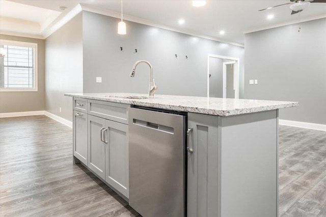 kitchen featuring light hardwood / wood-style flooring, stainless steel dishwasher, a center island with sink, and hanging light fixtures