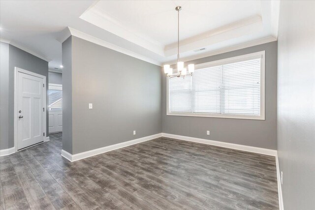 empty room with crown molding, a raised ceiling, and dark hardwood / wood-style floors