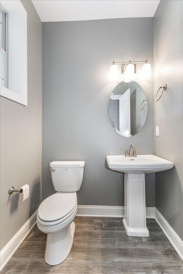 bathroom with toilet and hardwood / wood-style floors