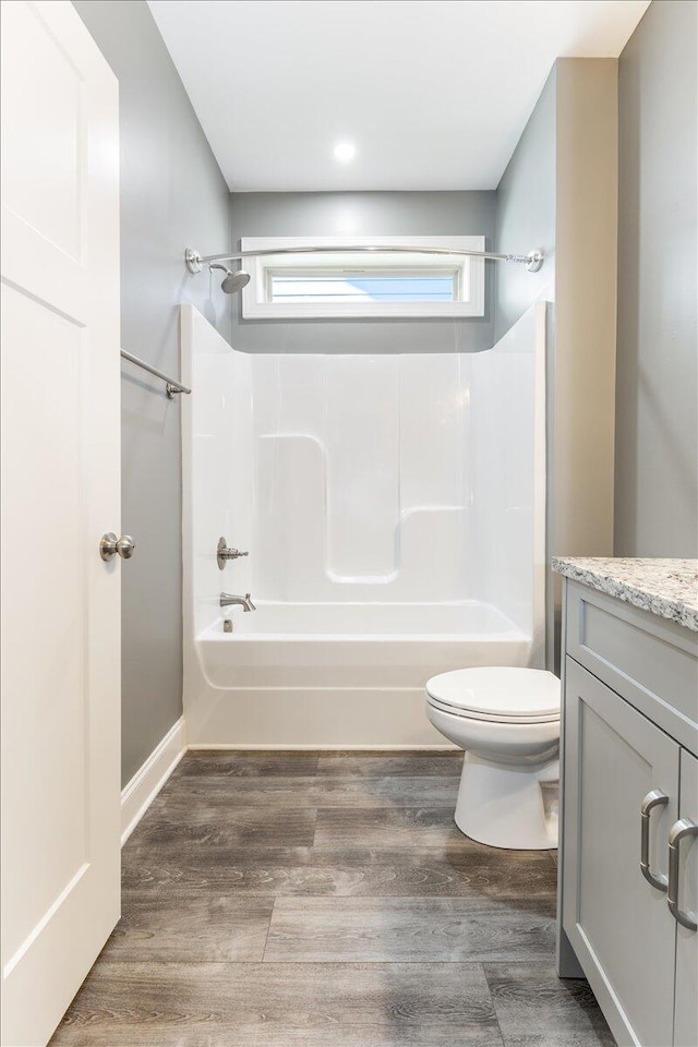 full bathroom featuring toilet, bathtub / shower combination, hardwood / wood-style flooring, and vanity