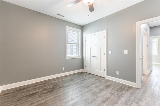 spare room featuring a wealth of natural light, hardwood / wood-style floors, and ceiling fan