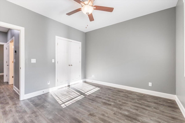 unfurnished bedroom with a closet, ceiling fan, and dark hardwood / wood-style floors