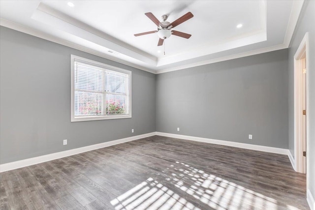 spare room with ceiling fan, a raised ceiling, wood-type flooring, and crown molding