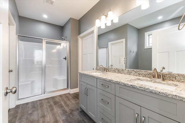 bathroom with vanity, an enclosed shower, and wood-type flooring