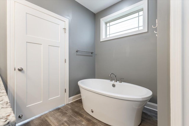 bathroom with wood-type flooring and a bathing tub