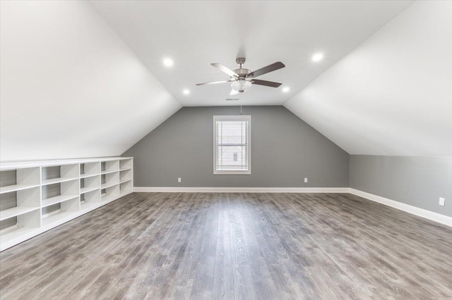 additional living space featuring lofted ceiling, hardwood / wood-style flooring, and ceiling fan