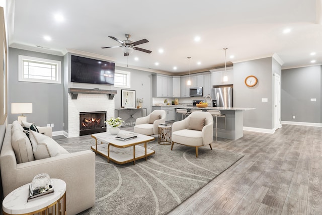 living room featuring crown molding, light wood-type flooring, and ceiling fan