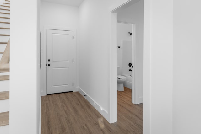 corridor with hardwood / wood-style flooring