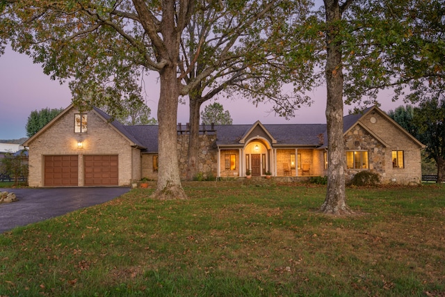 view of front of home featuring a garage and a lawn