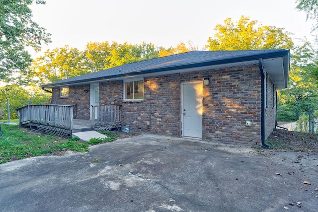 back of property featuring a wooden deck and a patio