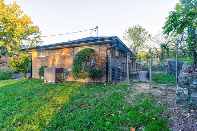 view of side of property with central air condition unit and a yard