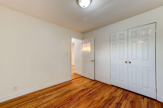 unfurnished bedroom with a closet and light wood-type flooring