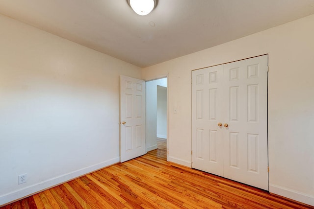 unfurnished bedroom with a closet and light hardwood / wood-style floors