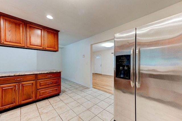 kitchen featuring stainless steel fridge with ice dispenser and light tile patterned floors