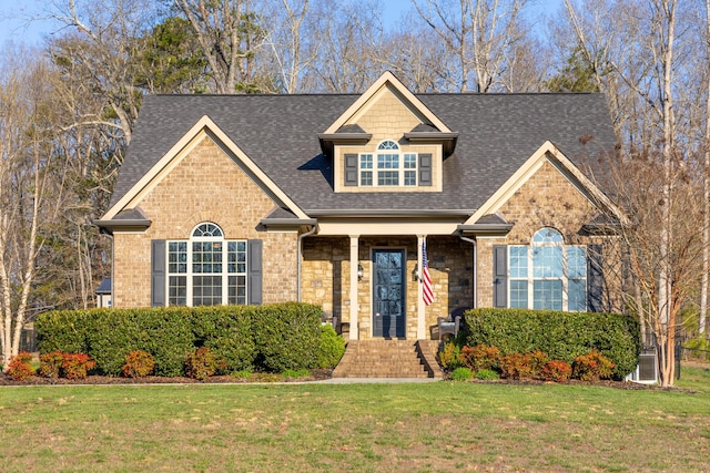 view of front of house with a front lawn and a shingled roof