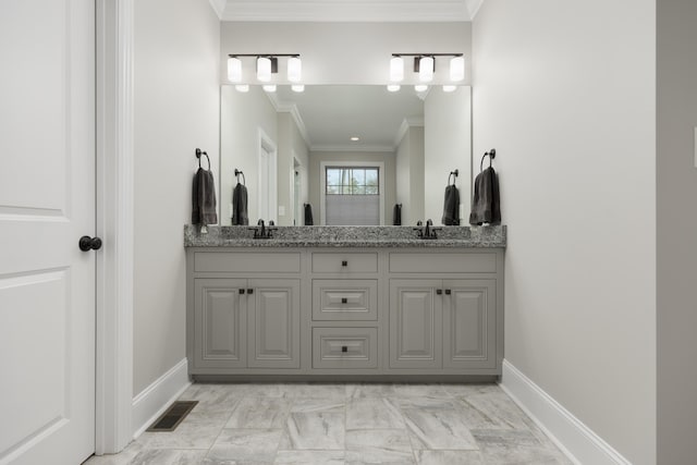 bathroom with visible vents, ornamental molding, a sink, double vanity, and baseboards