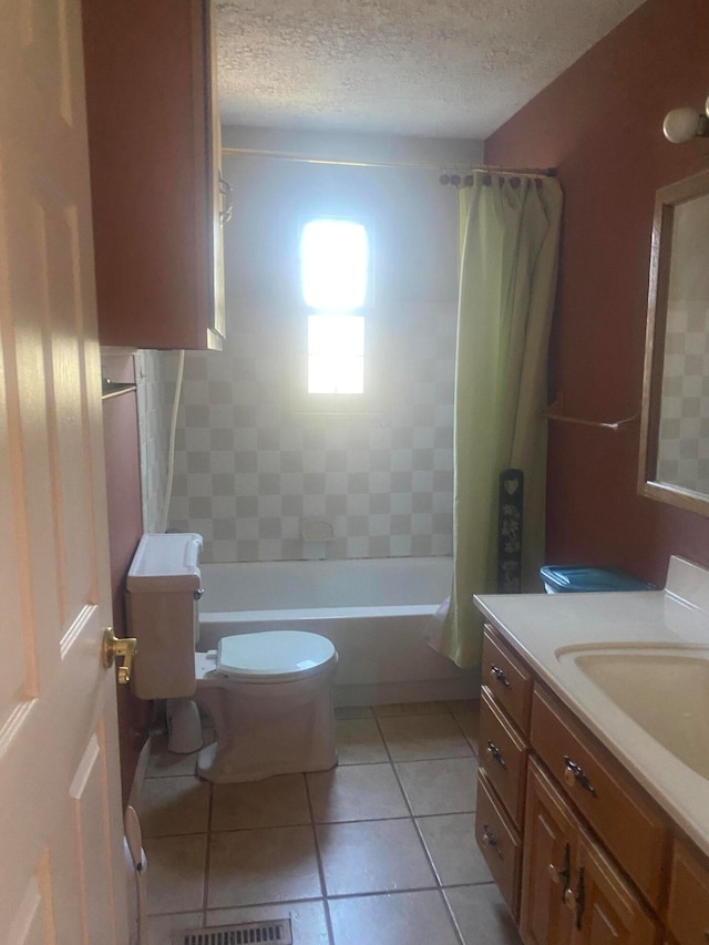 full bathroom with a textured ceiling, toilet, shower / bath combo, vanity, and tile patterned floors