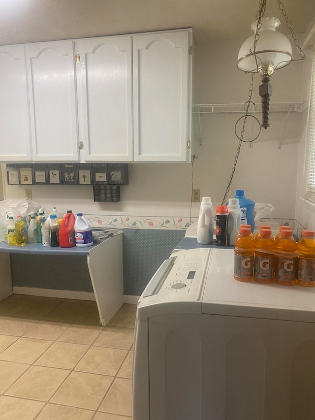 clothes washing area featuring independent washer and dryer, cabinets, and light tile patterned flooring