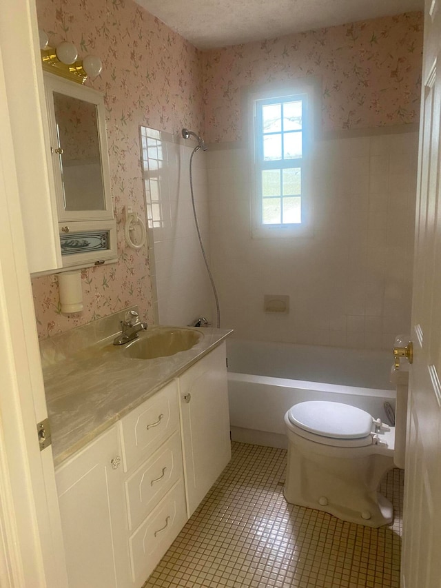 full bathroom featuring vanity, toilet, tiled shower / bath combo, and tile patterned flooring