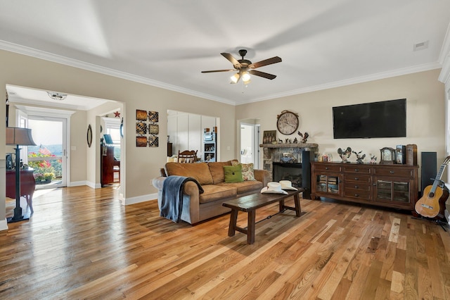 living room featuring light hardwood / wood-style floors, crown molding, and ceiling fan