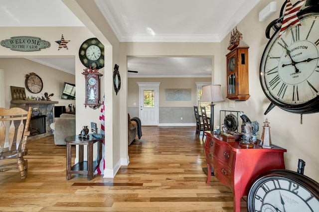 hall with ornamental molding and light hardwood / wood-style flooring