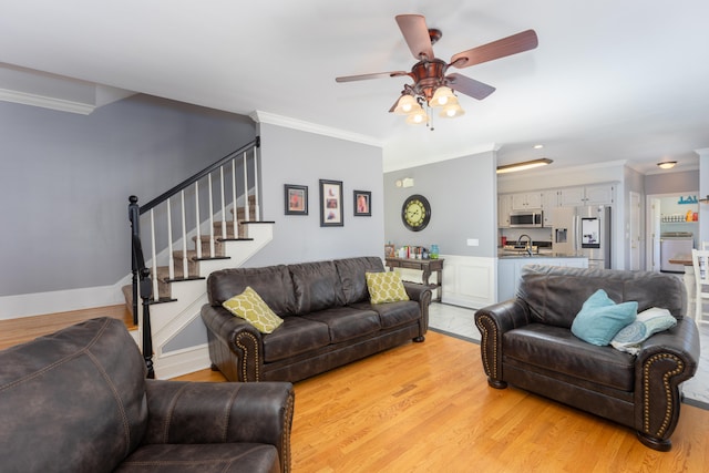 living room with crown molding, light wood-type flooring, and ceiling fan