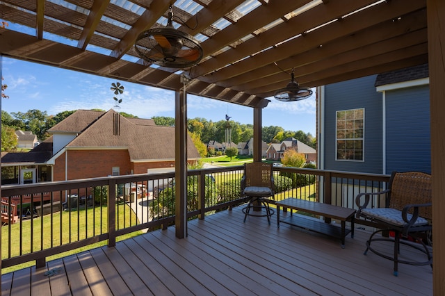 deck featuring ceiling fan, a lawn, and a pergola