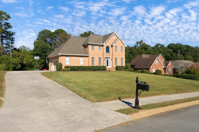 colonial home with a front yard and a garage