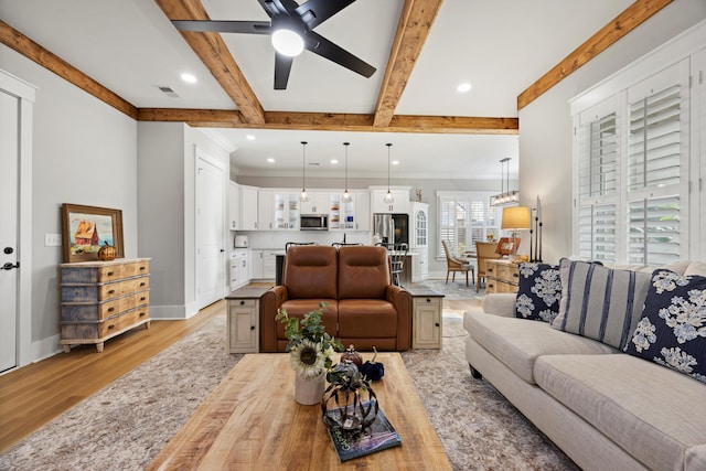 living room featuring beamed ceiling, ceiling fan, and light hardwood / wood-style flooring