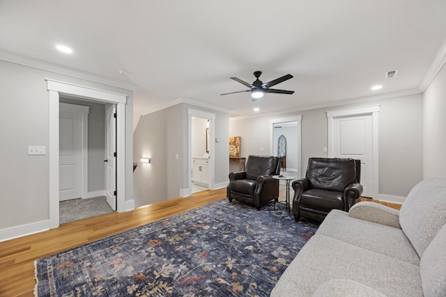 living room with wood-type flooring, ceiling fan, and crown molding