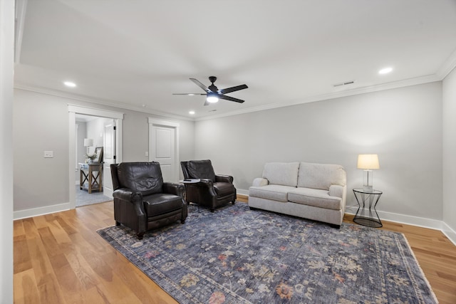 living room with hardwood / wood-style floors, crown molding, and ceiling fan