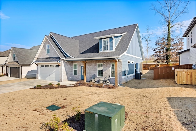 view of front of house featuring a garage, central AC unit, and covered porch