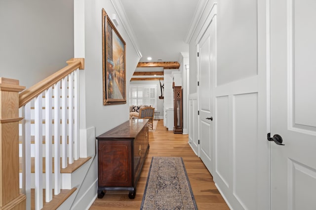 hall with ornamental molding and light hardwood / wood-style floors