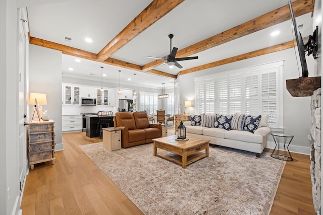 living room featuring beam ceiling, light hardwood / wood-style floors, and ceiling fan