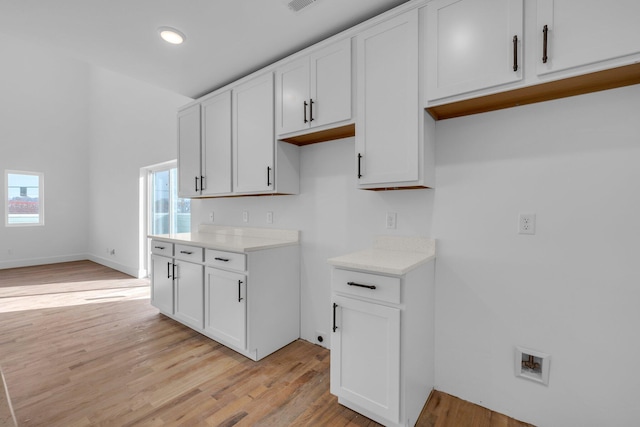 kitchen with light hardwood / wood-style floors, white cabinetry, and a wealth of natural light