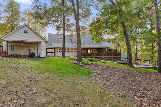 rear view of house featuring a yard and a sunroom