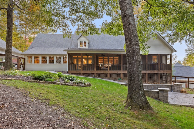 back of house with a lawn and a sunroom