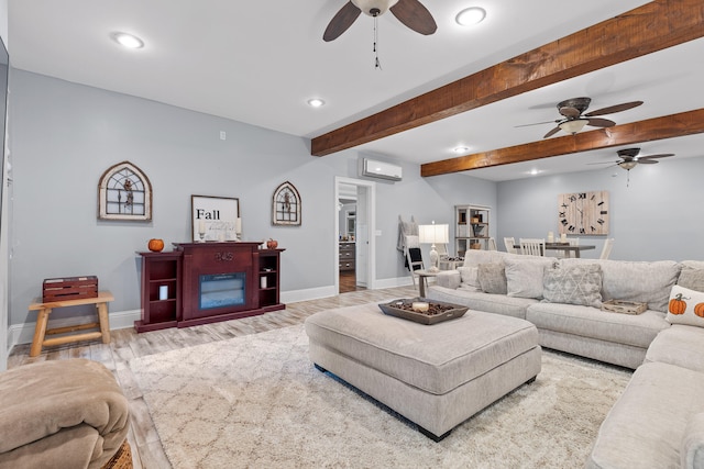 living room with an AC wall unit, beamed ceiling, and light hardwood / wood-style floors