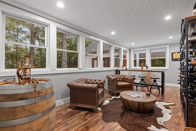 sitting room with wood walls, wood ceiling, and hardwood / wood-style flooring