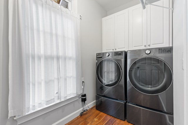 laundry room with cabinets, independent washer and dryer, and hardwood / wood-style flooring