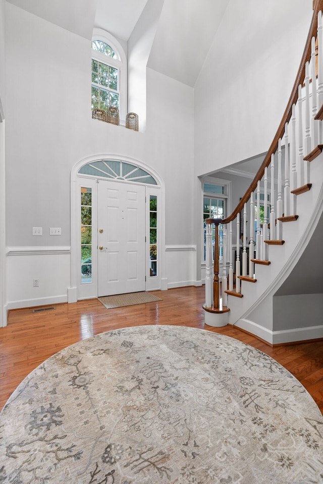 entrance foyer featuring high vaulted ceiling and hardwood / wood-style flooring