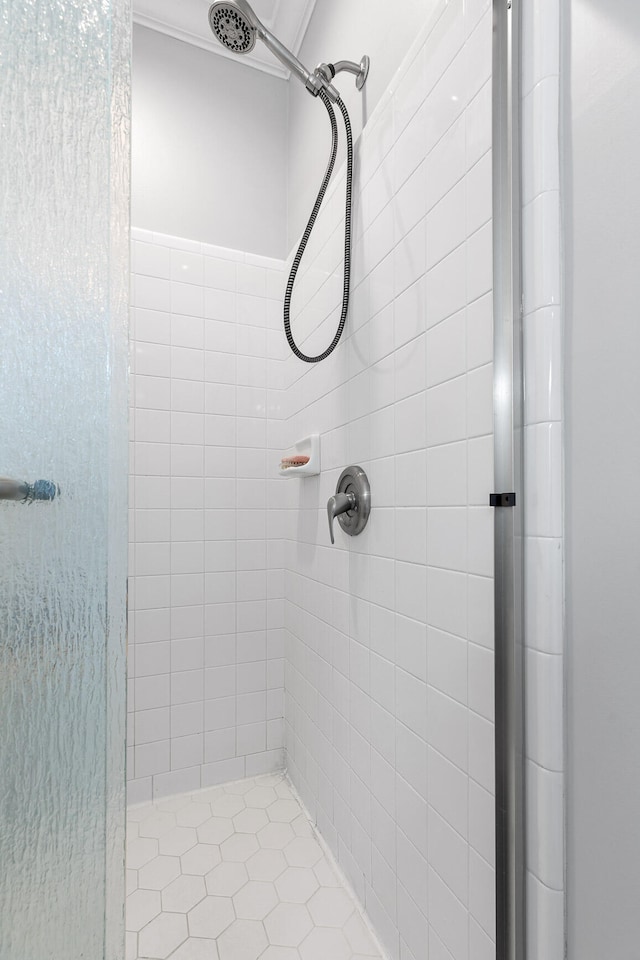 bathroom with a tile shower and tile patterned floors