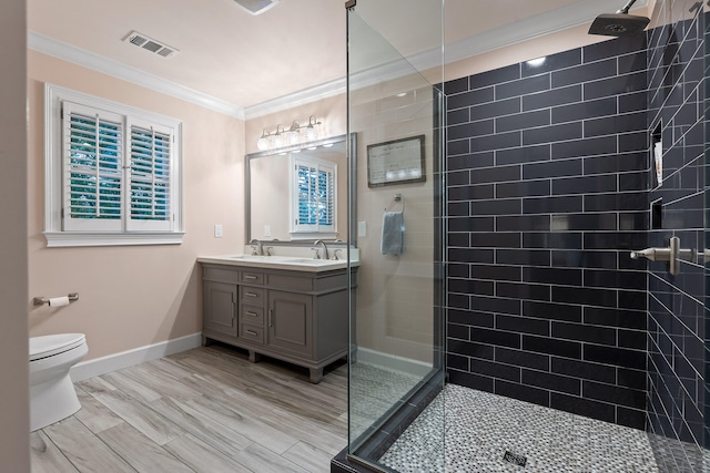 bathroom featuring tiled shower, toilet, vanity, and ornamental molding