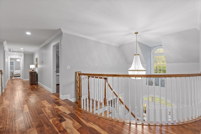 hall with hardwood / wood-style floors, lofted ceiling, and crown molding