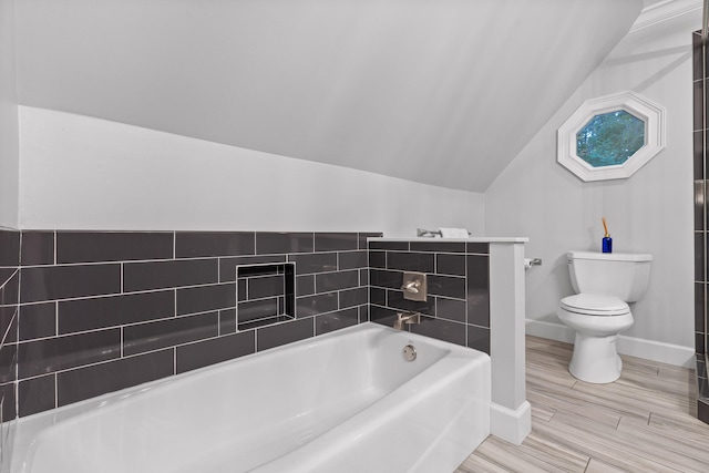 bathroom with hardwood / wood-style floors, a tub to relax in, toilet, and lofted ceiling