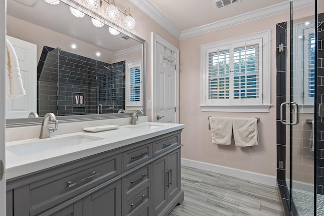 bathroom featuring vanity, a shower with door, and crown molding